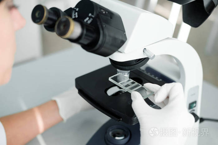 用显微镜近距离观察科学家的手，在实验室检查样品