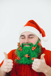圣诞老人穿着红色的衣服，戴着红色蝴蝶结装饰的绿色胡须，上面挂着拇指标志