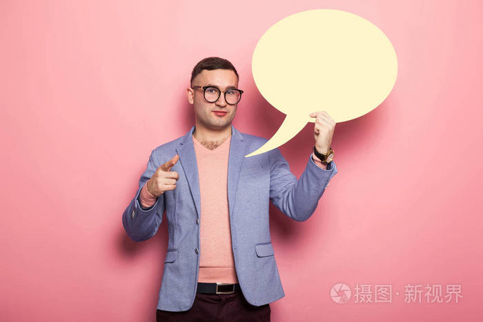一个英俊的年轻人拿着白纸说话泡泡指着照相机