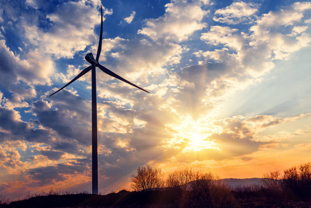 美丽的日落上的风车涡轮。 工业景观