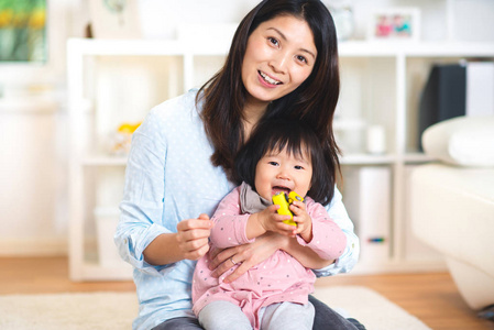 一个漂亮的日本母亲的肖像抱着她可爱的婴儿女儿