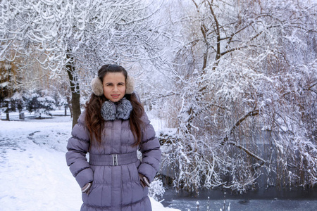 一位年轻女子的画像在冬天的公园里散步