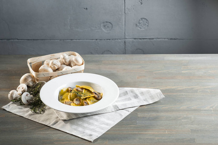 意大利面馄饨与蘑菇在暗光背景下。 自制意大利传统食品照片。