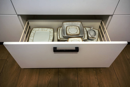 打开厨房抽屉，里面有盘子，用于厨房储存和组织的智能解决方案。
