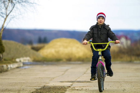 小男孩在户外公园骑自行车