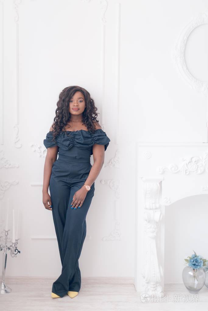 穿着连衣裙的漂亮年轻的非裔美国女人在工作室里摆姿势