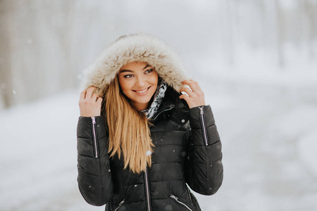 一个年轻漂亮的黑发女人，在下雪的冬天戴着头巾