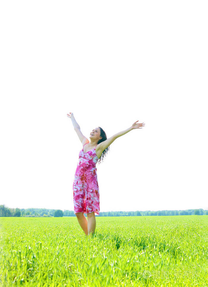 年轻快乐的女人在绿野上举起双手绿草地