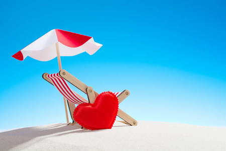 小心脏和椅子为放松在海滩图片