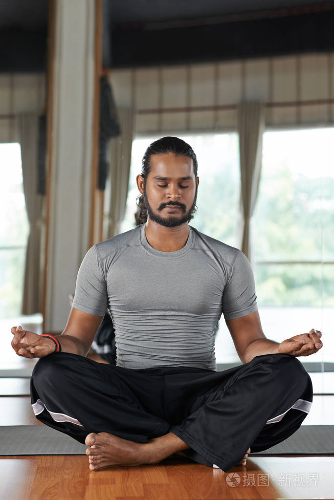 的印度男人坐在莲花的位置闭着眼睛