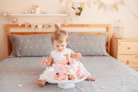 可爱可爱的白种人金发女婴的肖像，穿着白色连衣裙庆祝她的第一个生日。 一年一度的概念