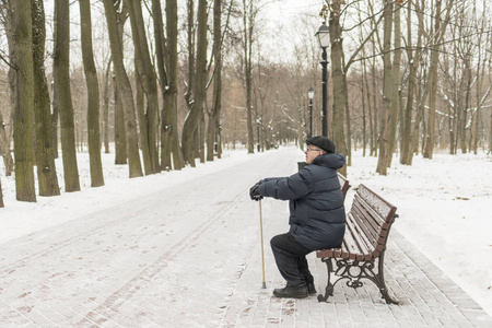 老人养老金领取人, 冬天坐在公园的长凳上。hig