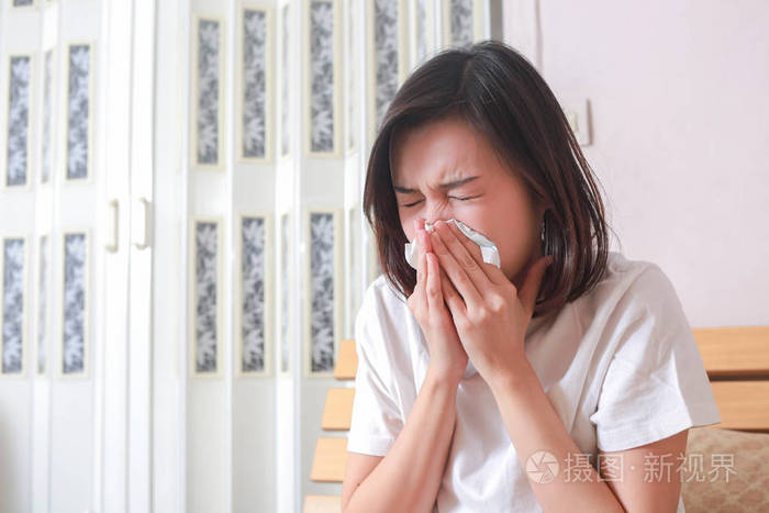 亚洲女人坐在床上擤鼻涕病症妇女