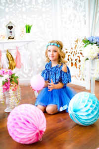 一幅美丽的小女孩的画像在一个装饰着许多彩色气球的工作室里笑