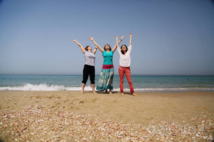 三位40岁的美女在海边散步的画像