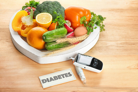 数字葡萄糖计，柳叶刀笔，水果和蔬菜在桌子上。 糖尿病饮食