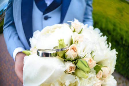 结婚戒指躺在美丽的花束作为新娘配件