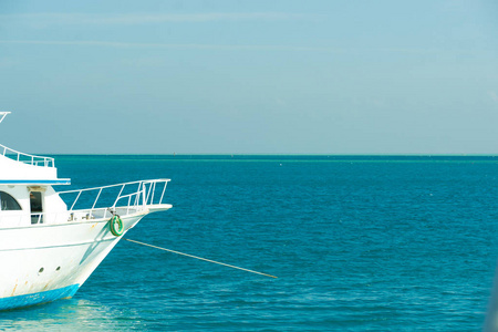 阳光明媚的一天，白色游艇在海上长长的地平线上。