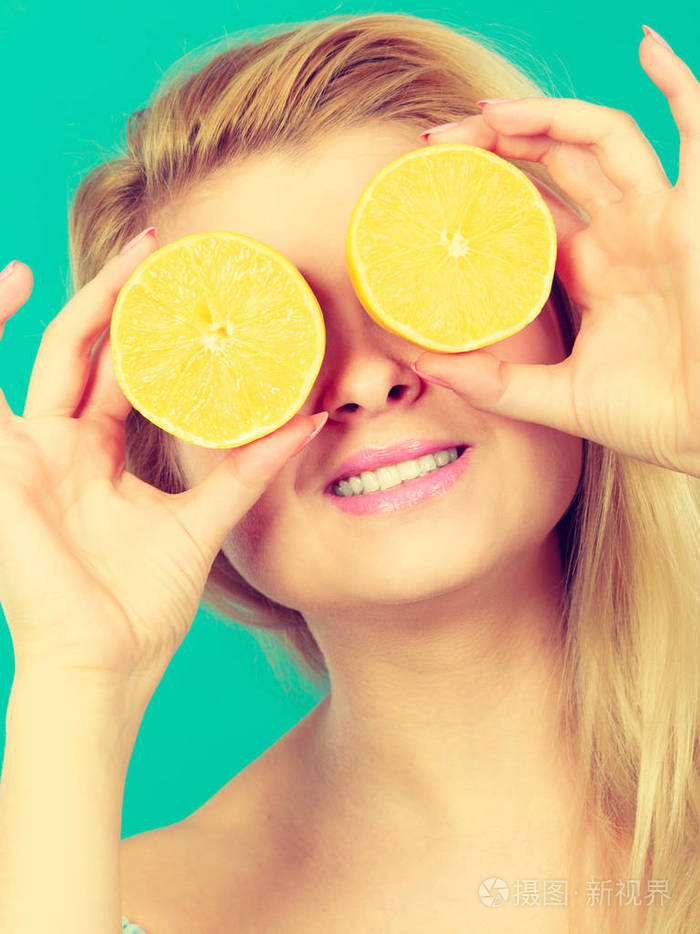 遮住她的眼睛与柠檬柑橘类水果的女孩