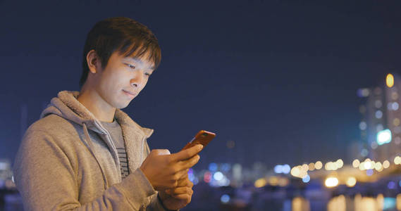 在户外夜晚使用智能手机的人图片