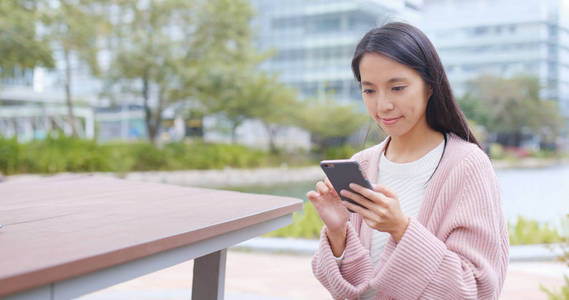 女人在城市里看智能手机