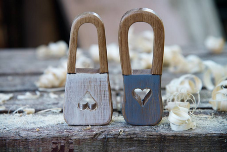 手工挂锁木制玩具。木制刨花的背景。美丽的钥匙孔在心脏形状和古典钥匙孔
