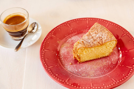 一块美味的胡萝卜馅饼在一个红色闪亮的盘子上。一份自制的纸杯蛋糕, 上面有黑咖啡。自制馅饼放在白色木桌上的陶瓷盘子里