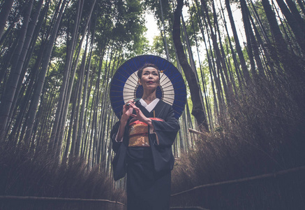 美丽的日本高级妇女走在竹林里图片