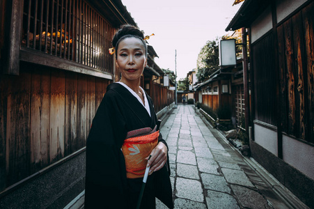 美丽的日本高级妇女走在村里。典型