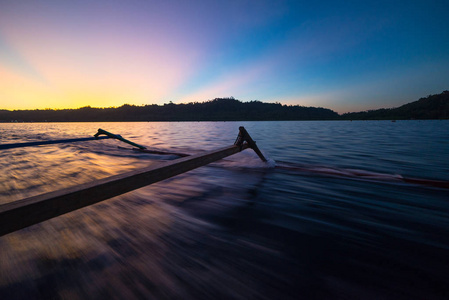 Togean 群岛日落, Togian 群岛旅游目的地, 印尼。帆船由传统船, 令人惊叹的多彩天空, 模糊的运动