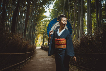 美丽的日本高级妇女走在竹林里图片