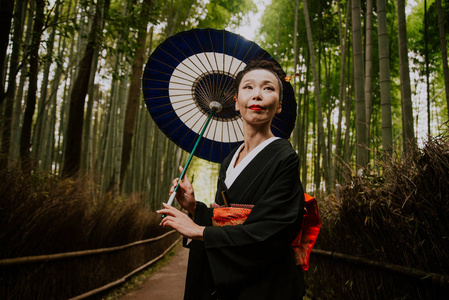 美丽的日本高级妇女走在竹林里图片