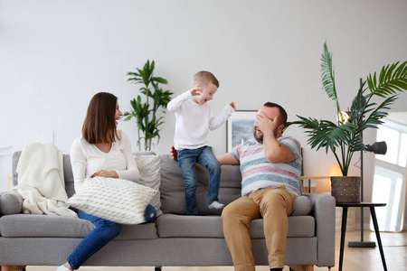 快乐父母的图片与儿子在灰色沙发