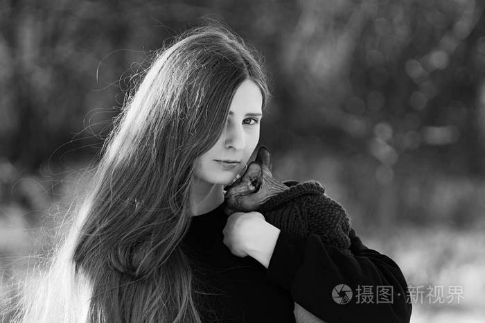 的女孩她的猫在她的怀里在一个晴朗的日子里的冬天公园里猫养殖瑞士