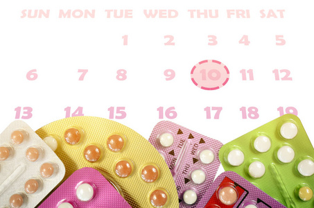口服避孕药带分离在白色背景与日历在避孕教育概念。