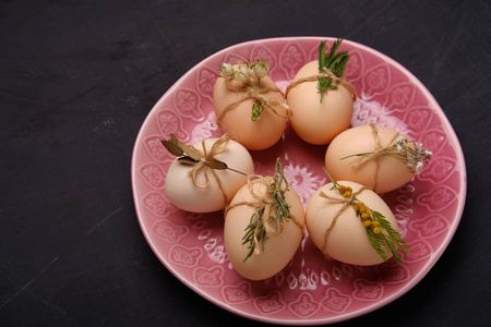 新鲜鸡肉和鹌鹑蛋在粉红色的盘子里。顶部视图。健康食品与有机农业概念