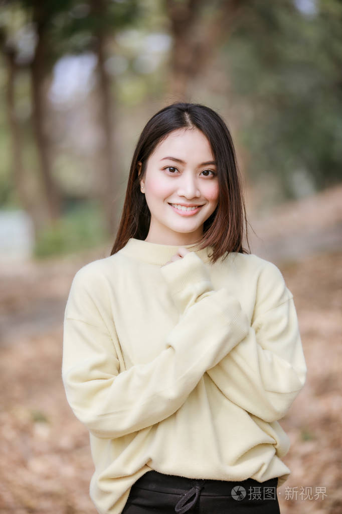 女人,微笑着,快乐的女孩,穿着温暖的衣服,在公园的的肖像在公园的户外