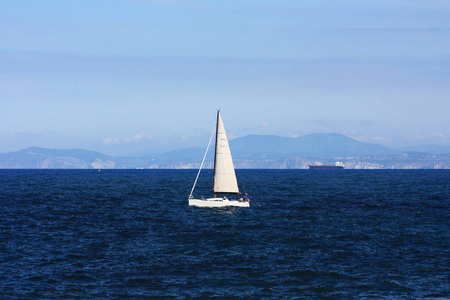 白色游艇在水中隔离在蓝色背景上