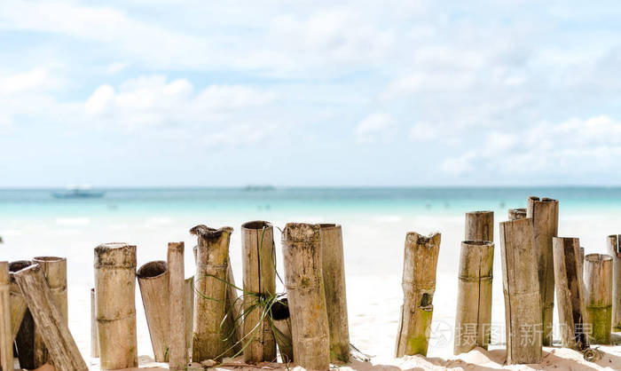在菲律宾长滩岛热带海滩上的竹栅栏和热带透明海水纹理反射