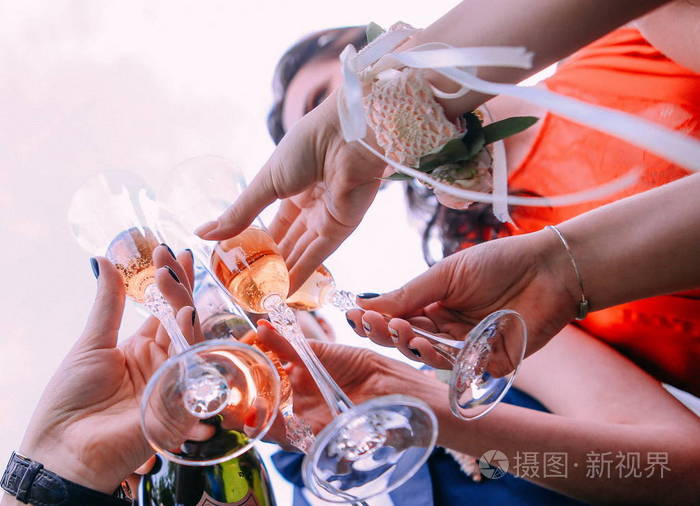 朋友们喝香槟在天空外举起酒杯