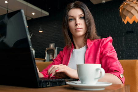 年轻, 漂亮的女孩, 女商人, 坐在咖啡馆和工作的笔记本电脑。商务午餐, 咖啡杯, 成功的商业女性