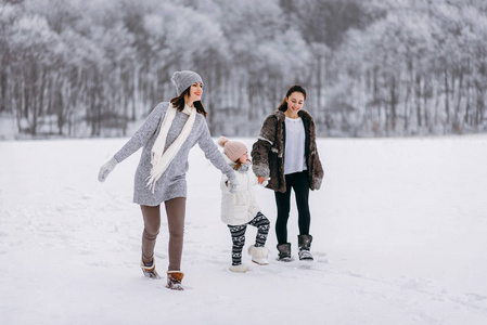 冬季公园背景下一家人在雪地上奔跑的侧景