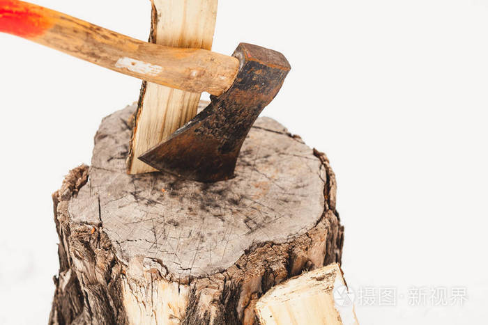 斧头伸出在附近劈开的原木上的一个树桩上. 在第二根圆木的附近