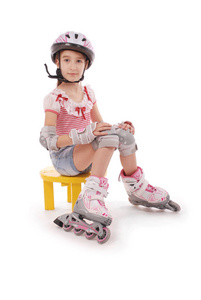 迷人的布朗头发的女孩在学校的年龄短牛仔裤短裤和粉红色的 t恤坐在椅子上, 并试图步行旱冰鞋