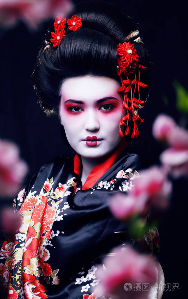 年轻漂亮的艺伎和服与樱花和装饰