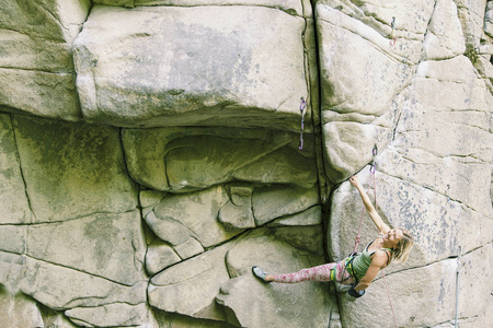 女孩爬上攀岩路线上的岩石