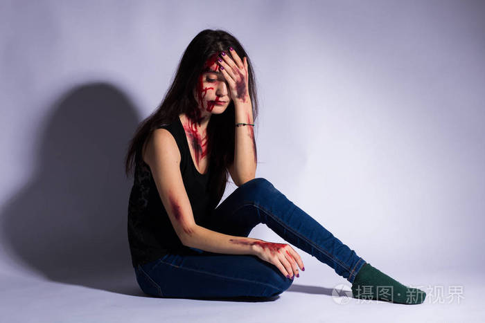 强奸被殴打的受害者悲伤的女人坐在黑暗的隧道的地板上.