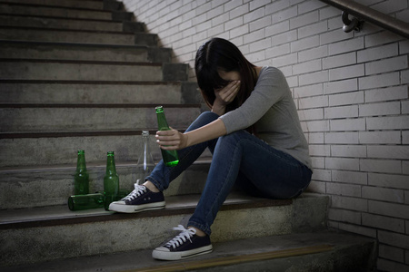 抑郁的女人在地下酗酒时感到不安