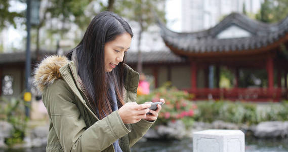 中国亭园女子手机玩游戏图片