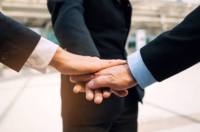 亲密的三个商人团队携在现代城市团队领导成功支持会议